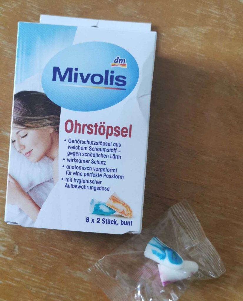 Ohrstöpsel-Schlafen-Test: Ohrstöpsel liegen neben Verpackung auf einem Holztisch.