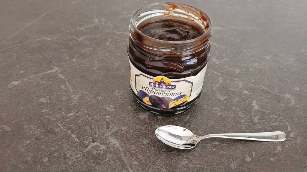 Pflaumenmus im Test: Ein geöffnetes Glas Mus mit einem Löffel daneben