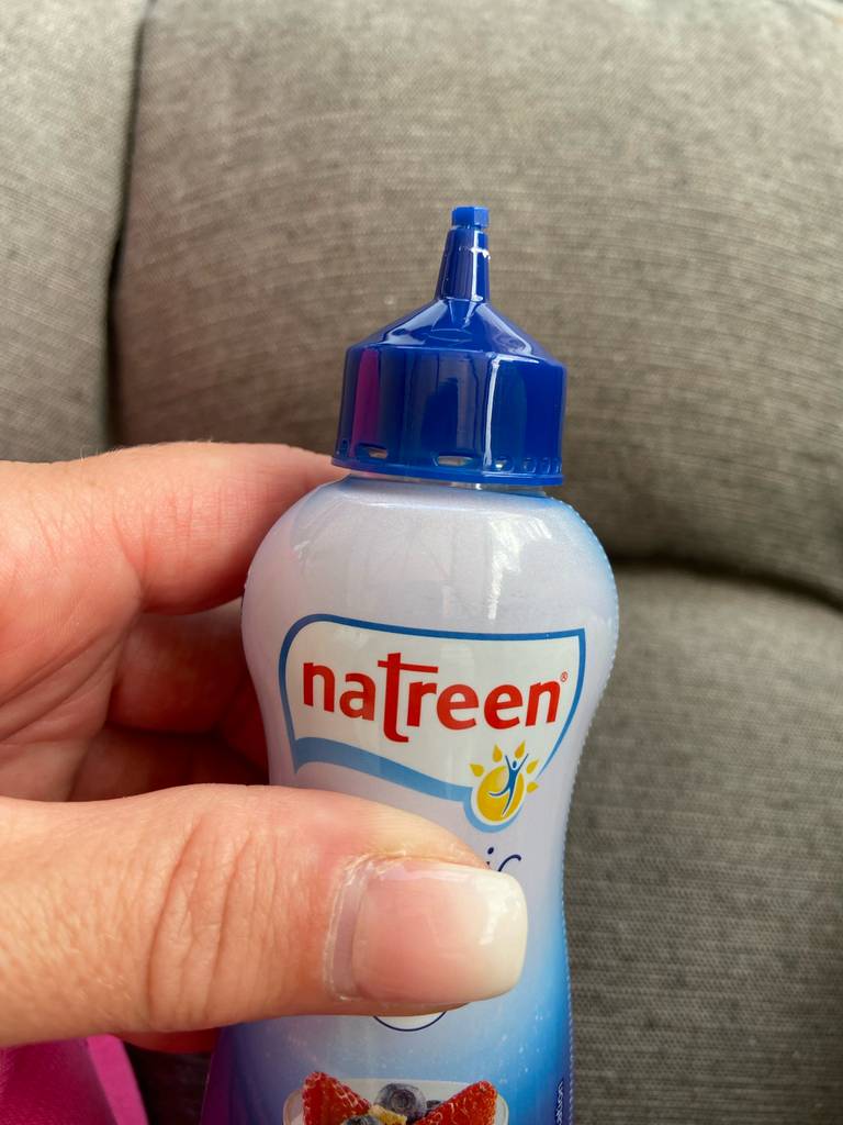 Der flüssige Süßstoff im Test wird in einer Kunststoffflasche von einer Hand gehalten.