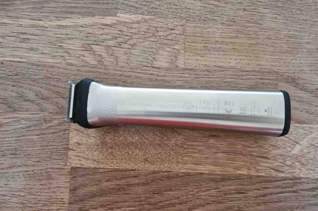 Im Test: Ein Philips-Rasierer liegt umgedreht auf einer Holzfläche, Zeichen auf dem Griff sichtbar