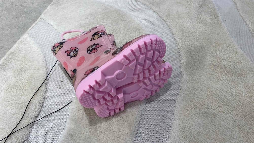 Im Test: Ein Paar Gummistiefel für Kinder liegen auf der Seite, Nahaufnahme der Sohlen.