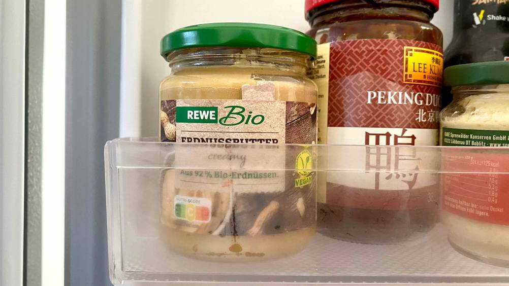 Im Test: Ein Glas Erdnussbutter steht in einer Kühlschranktür.