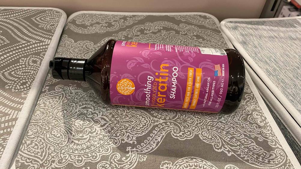 Im Test: Eine Flasche Keratin-Shampoo liegt horizontal auf einer gemusterten Matte.