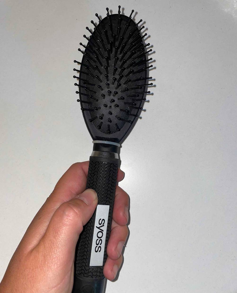 Haarbürste in der hand.