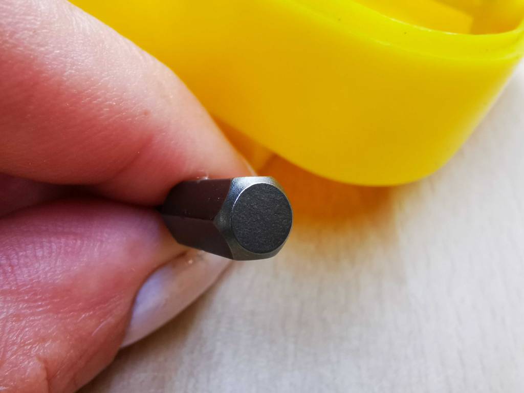 Eine Hand hält ein getestetes Torx-Bit in die Kamera.