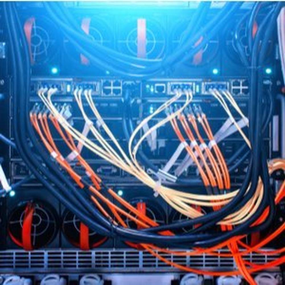 verschiedene Kabel, Anschlüsse und Switches sowie Kühler in einem Rack in einem Serverraum