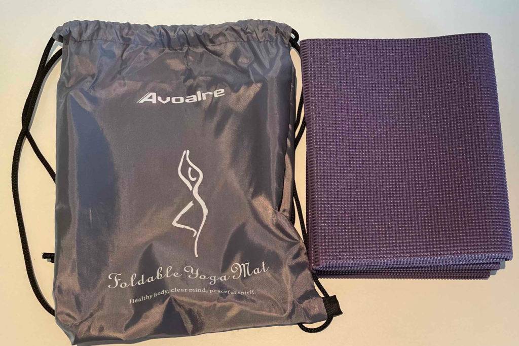 Reise-Yogamatte getestet: Die Matte und ihr Reisebeutel lehnen an einer hellen Wand