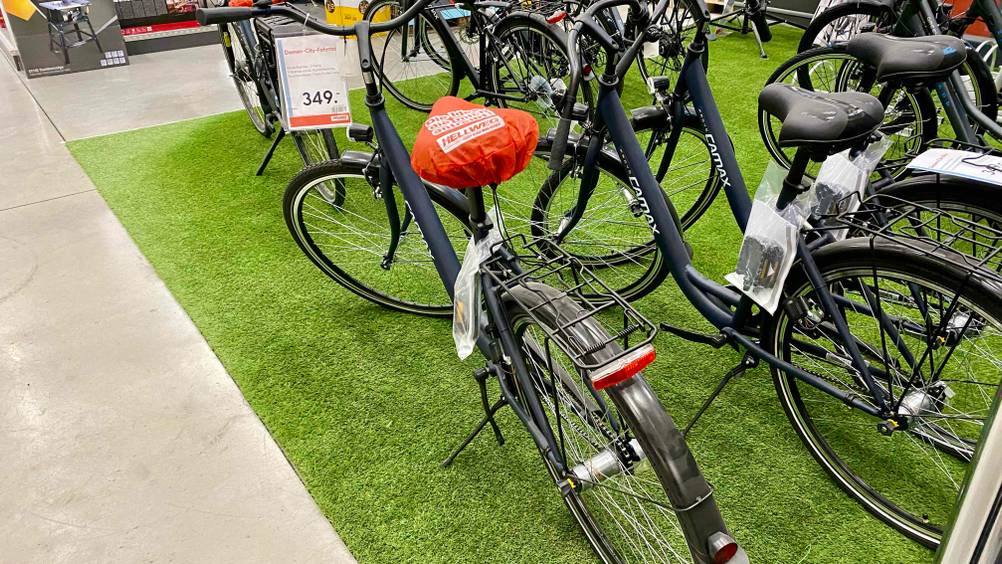 Fahrrad getestet: ein Fahrrad ist in einem Geschäft auf einem Rasenteppich neben anderen Fahrrädern ausgestellt.