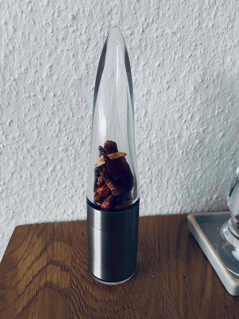 Auf einem Holztisch steht eine getestete Chilimühle.