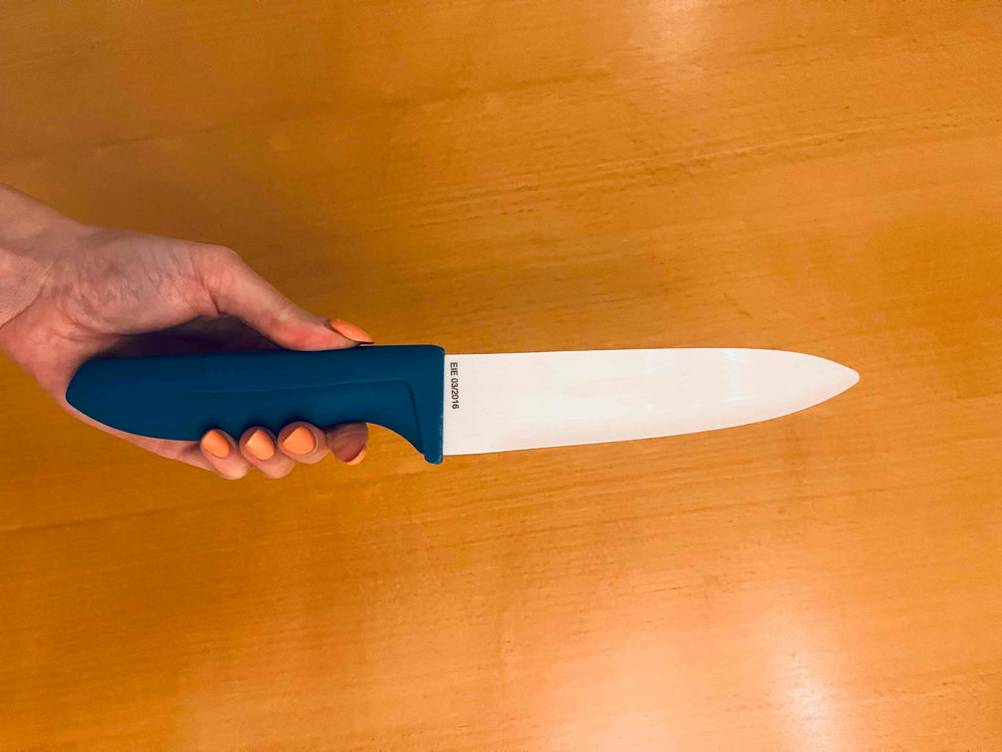 Keramikmesser-Test: Keramikmesser mit blauem Griff wird in der Hand gehalten.