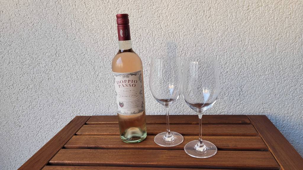 Roséwein und zwei leere Gläser.