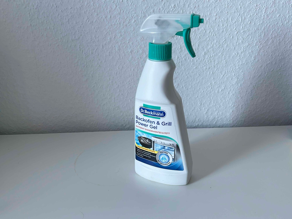 Ein getesteter Grillreiniger auf einer hellen Fläche vor einer weißen Wand.