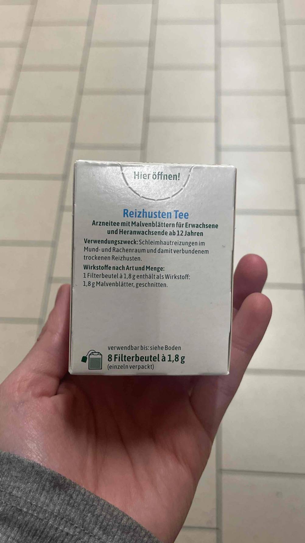 Der getestete Hustentee mit 8 Teebeuteln darin wird in der Hand gehalten.