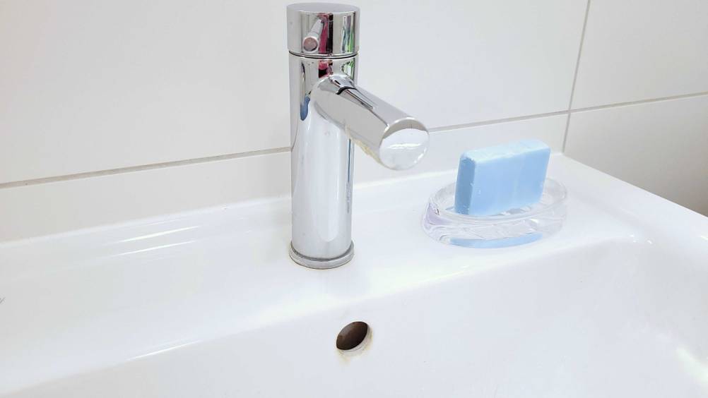 Im Test: Auf einem Waschbecken steht neben dem Wasserhahn eine Seifenschale mit Seife.
