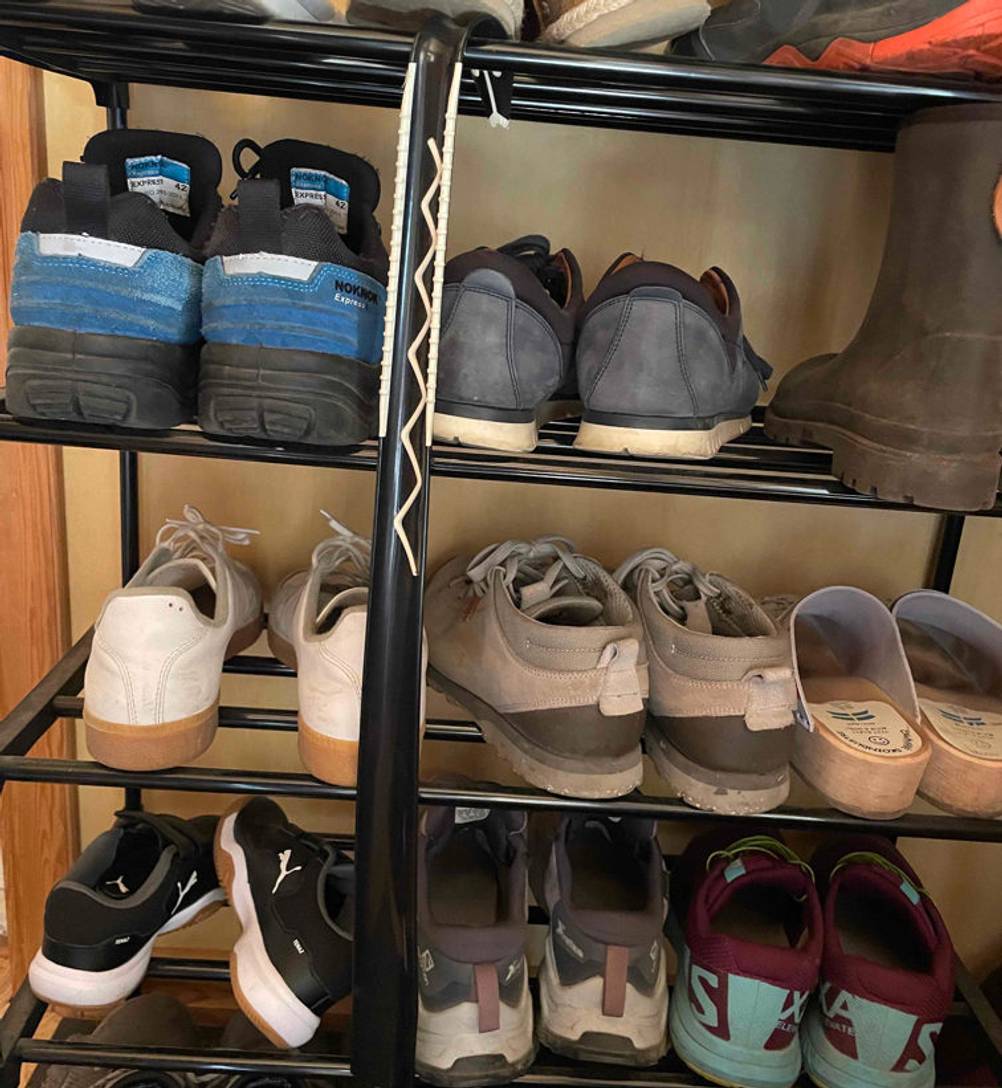 Schuhlöffel getestet: ein schwarzer Schuhlöffel hängt auf einem Schuhregal.