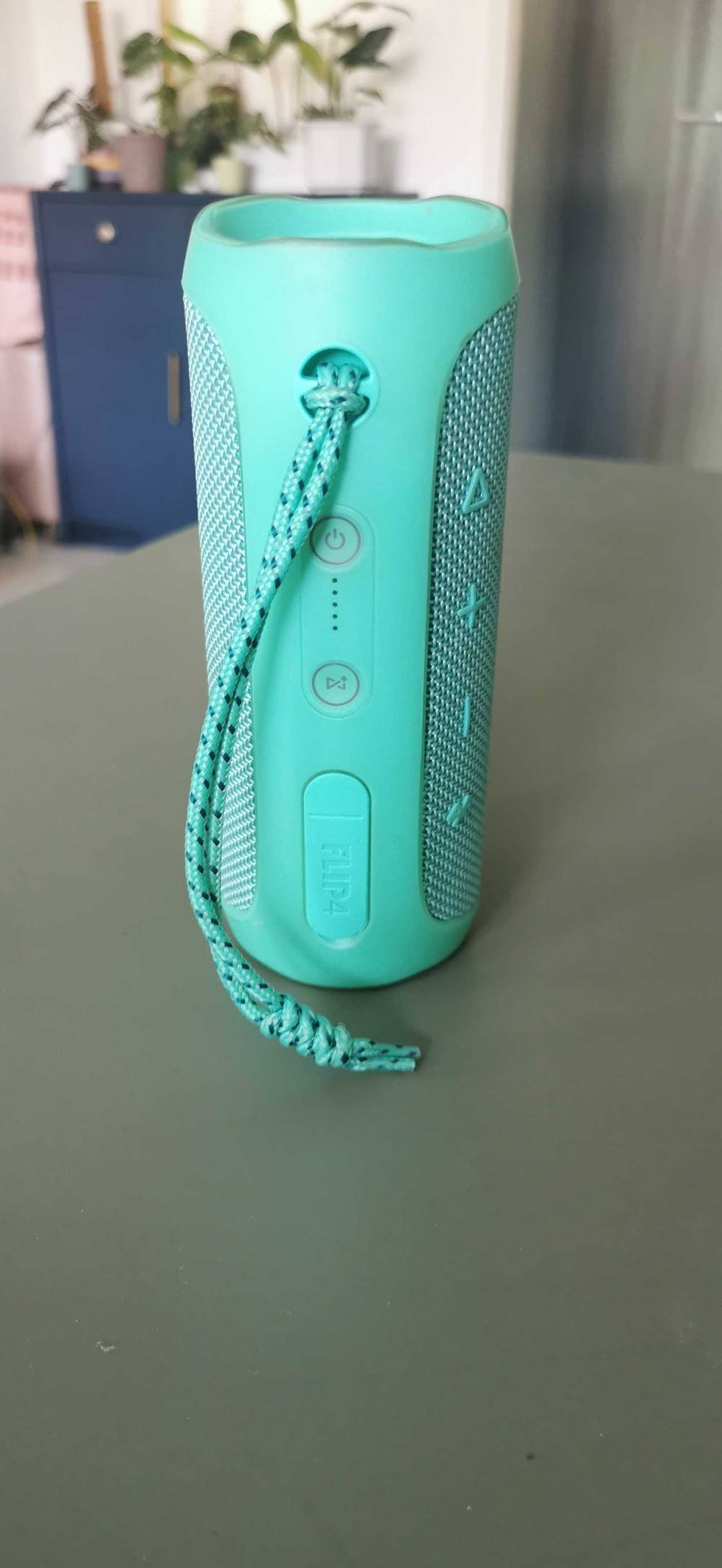 Ein getesteter Bluetooth-Lautsprecher (wasserdicht) mit Bedienelementen und Handschlaufe auf einem Tisch.