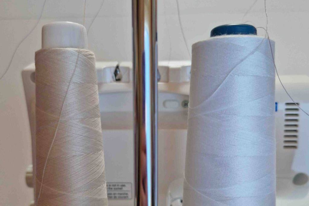 Overlock-Nähmaschine im Test: Zwei Spulenstifte mit Garn aufgerollt