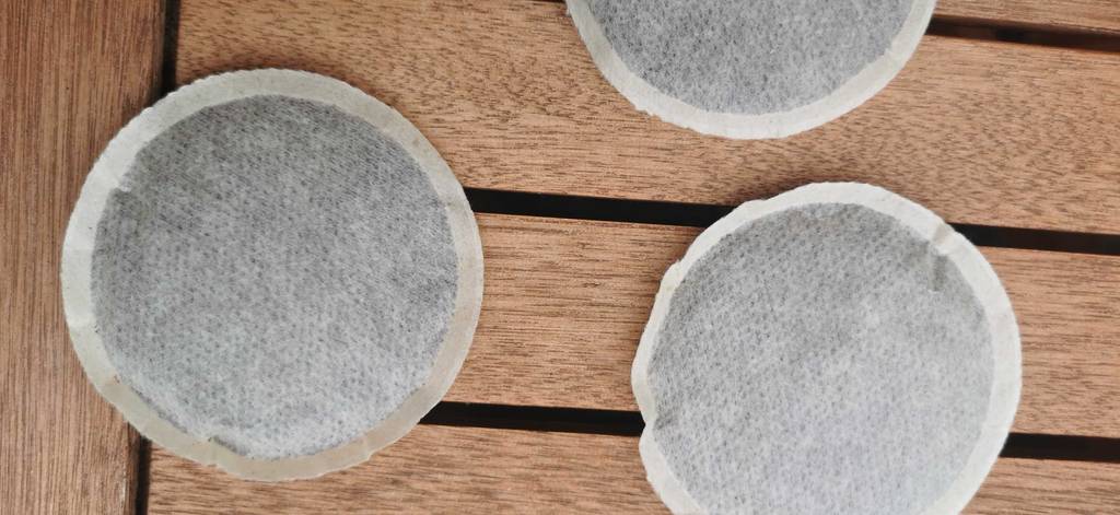 Drei Kaffeepads auf einem Holztisch.