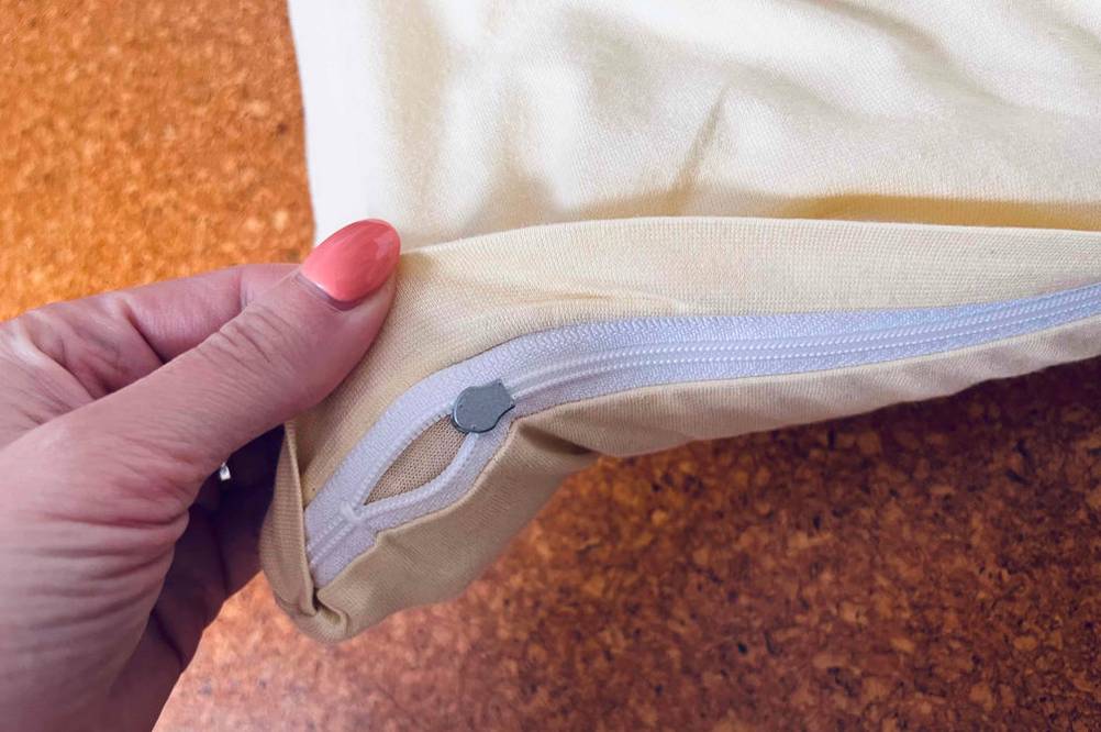 Im Test: Eine Hand hält den Reisverschluss eines Kopfkissen 40 x 80 nach oben.