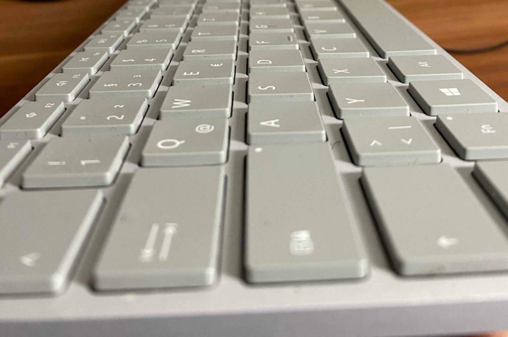 Im Test: Eine ergonomische Tastatur kabellos von der Seite auf einer Holzoberfläche.