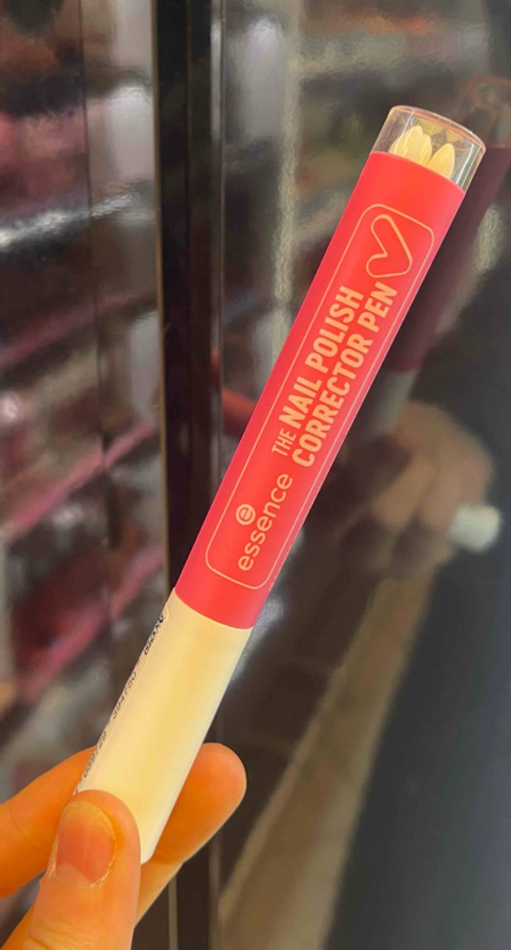 Der getestete Nagellack-Korrekturstift von Essence mit Ersatzspitzen wird in der Hand gehalten.