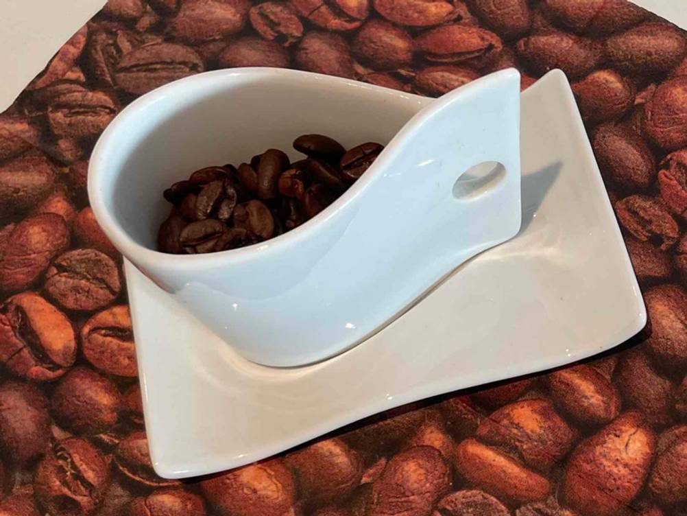 Espressobohnen getestet: Eine Espressotasse mit Espressobohnen gefüllt.