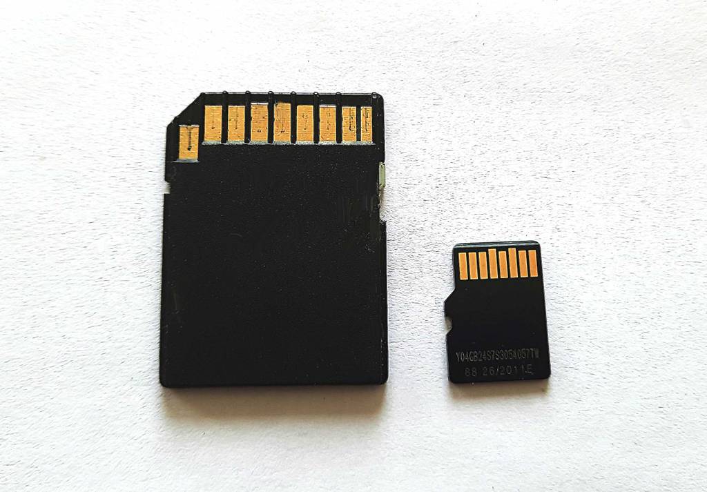 Der Micro-SD-Karten-Adapter und die SD-Karte von der Rückseite ersichtlich - auf einer weißen Fläche liegend.