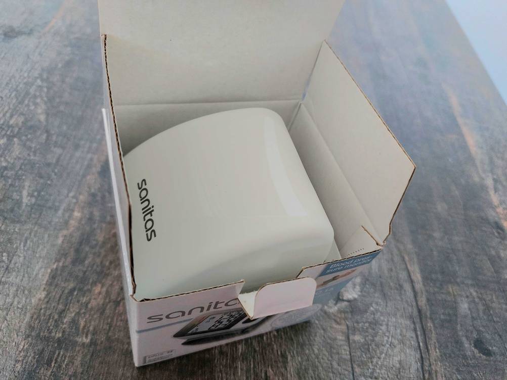 Im Test: Ein Sanitas-Blutdruckmessgerät in seiner geöffneten Verpackung.