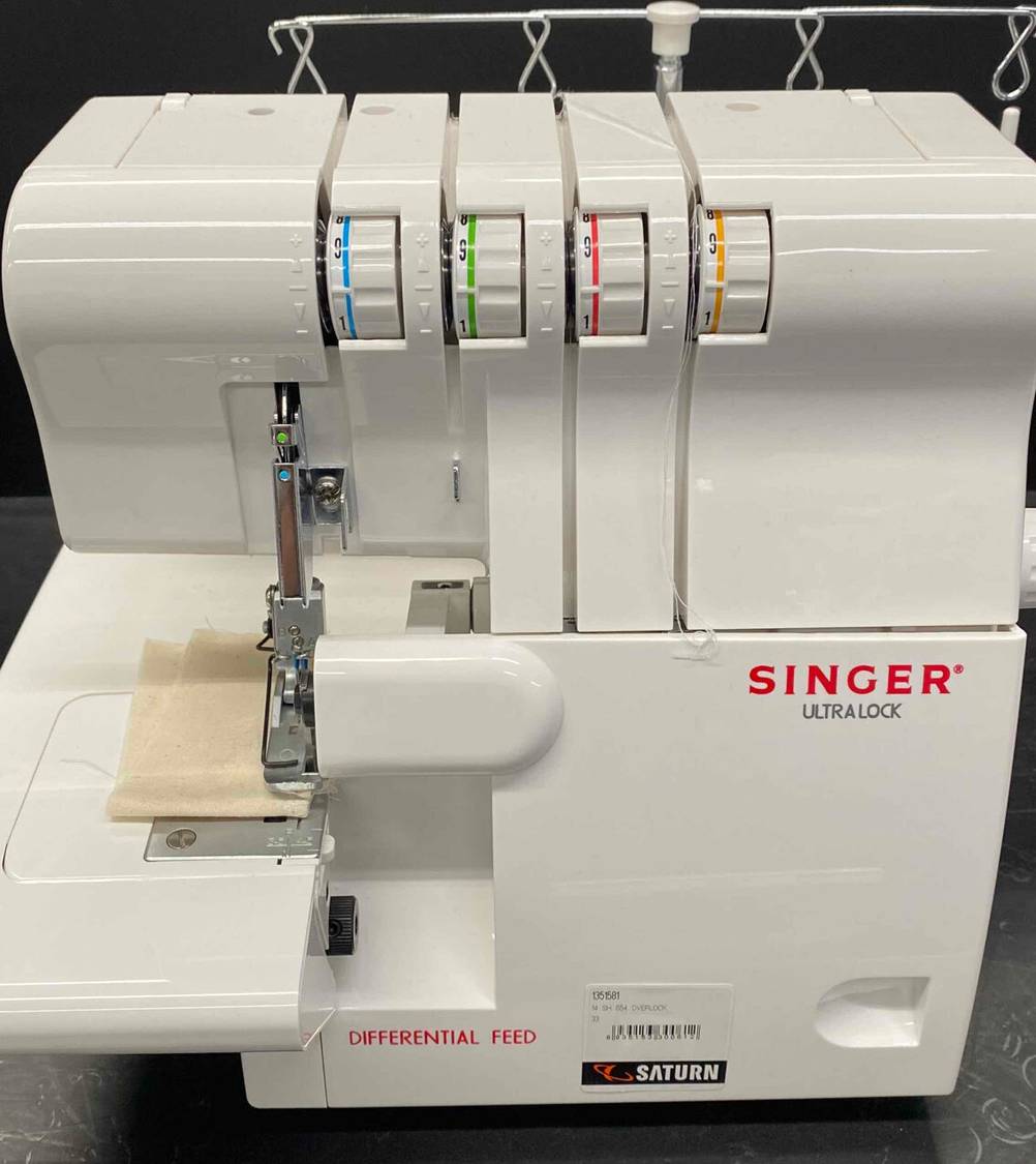 Eine Singer-Nähmaschine im Test von der Seite betrachtet. Es handelt sich um eine weiße Overlockmaschine. 