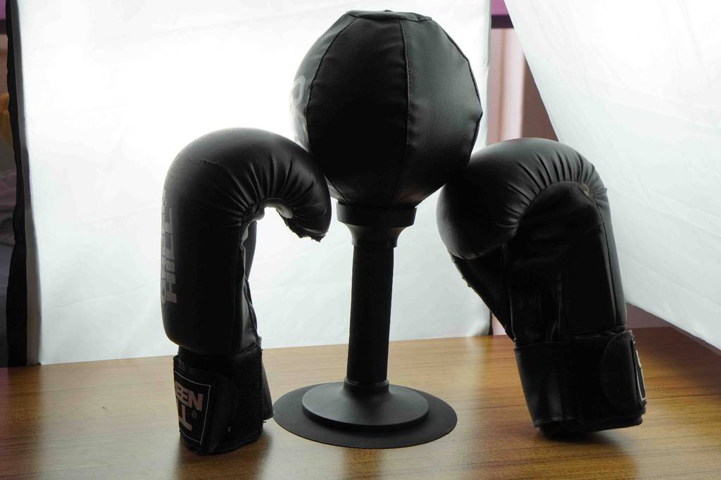 Zwei Boxhandschuhe neben getesteten Standboxsack