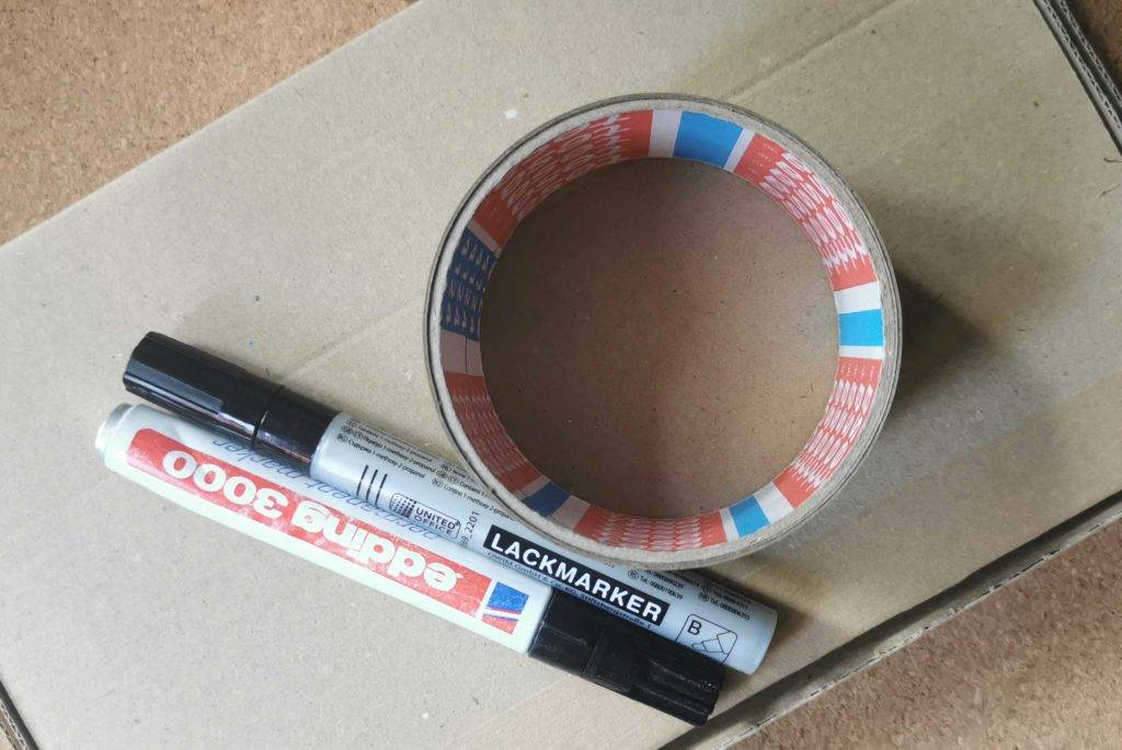 Paketband auf einem Karton mit Stiften.