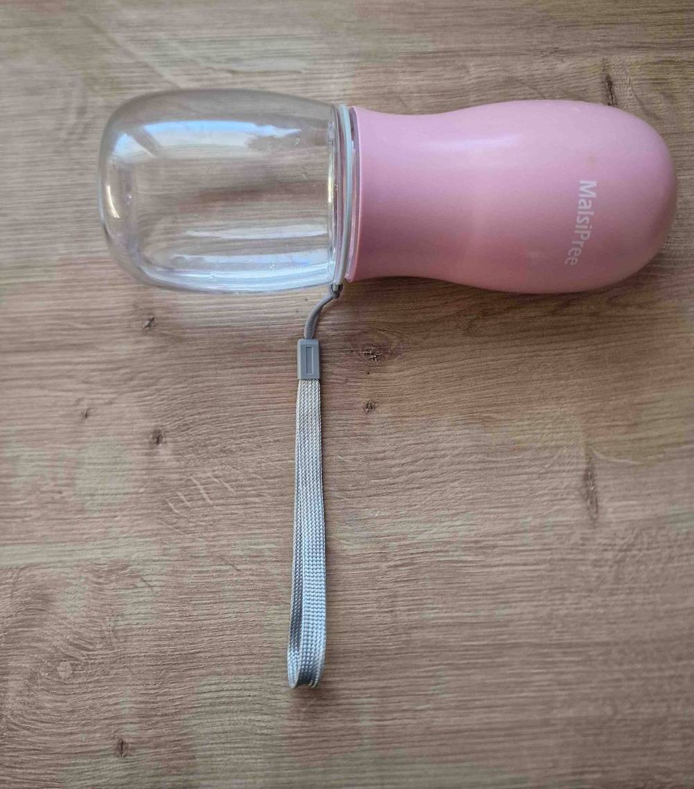 Hundeflasche getestet: eine liegende Hundeflasche in Rosa mit einem Bändchen darauf.