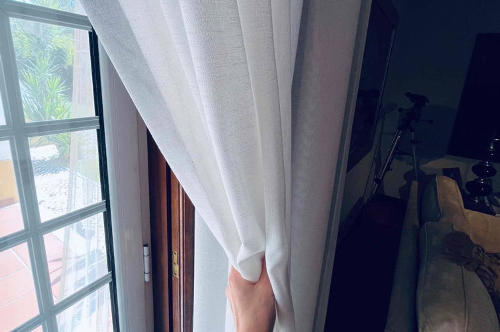 Im Test: Eine Hand schiebt einen Türvorhang zur Seite.