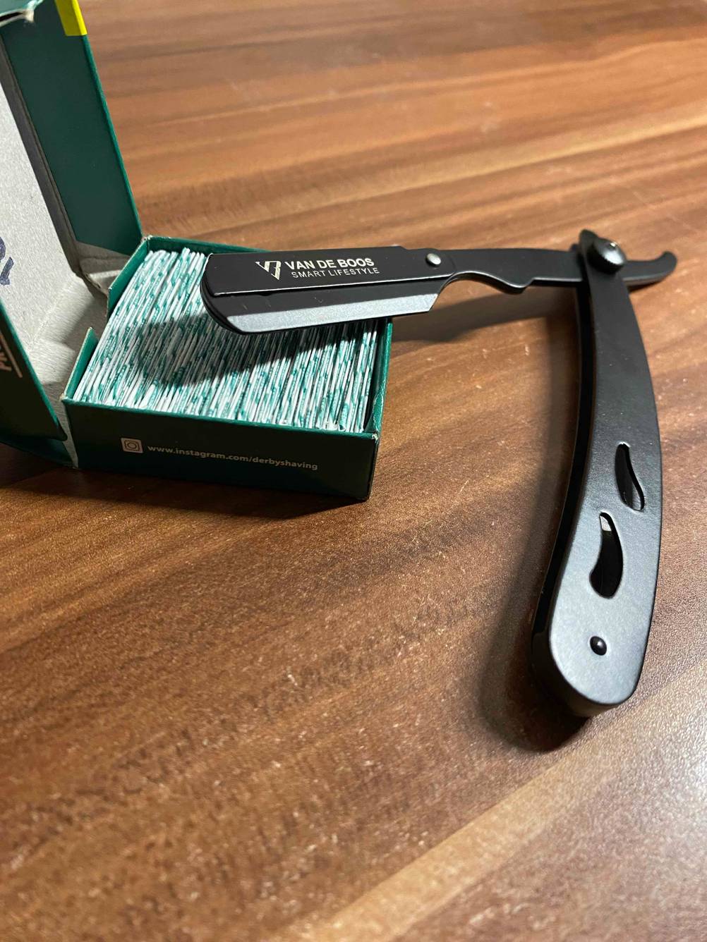 Rasiermesser getestet: Ein Messer liegt neben einer Packung Klingen auf einem Holzbelag.