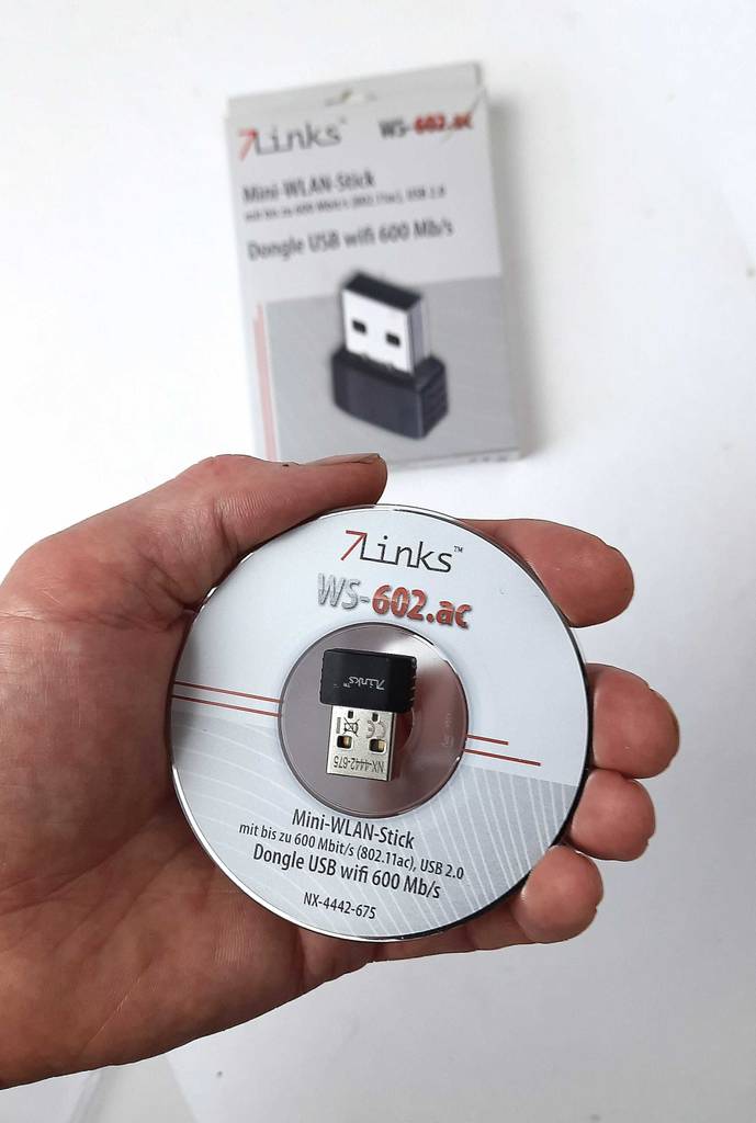 WLAN-Stick 5 GHz im Test: Eine Hand hält die Installations-CD inklusive WLAN-Stick vor einer weißen Wand.