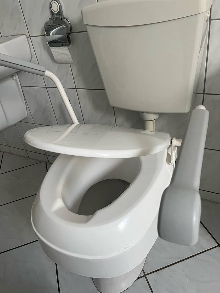 Toilettensitzerhöhung Die Toilettensitzerhöhung mit leicht göffneten Deckel.