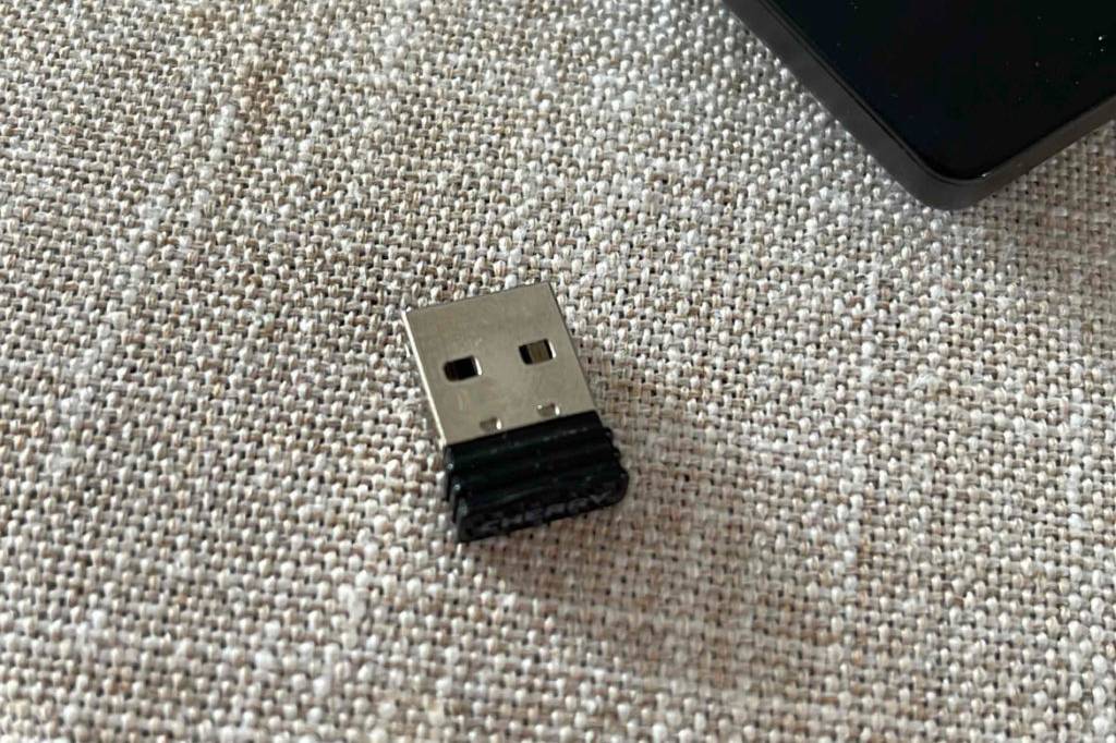 Bluetooth-Adapter getestet: Der Adapter liegt auf einem hellen Stoff neben einem Computer