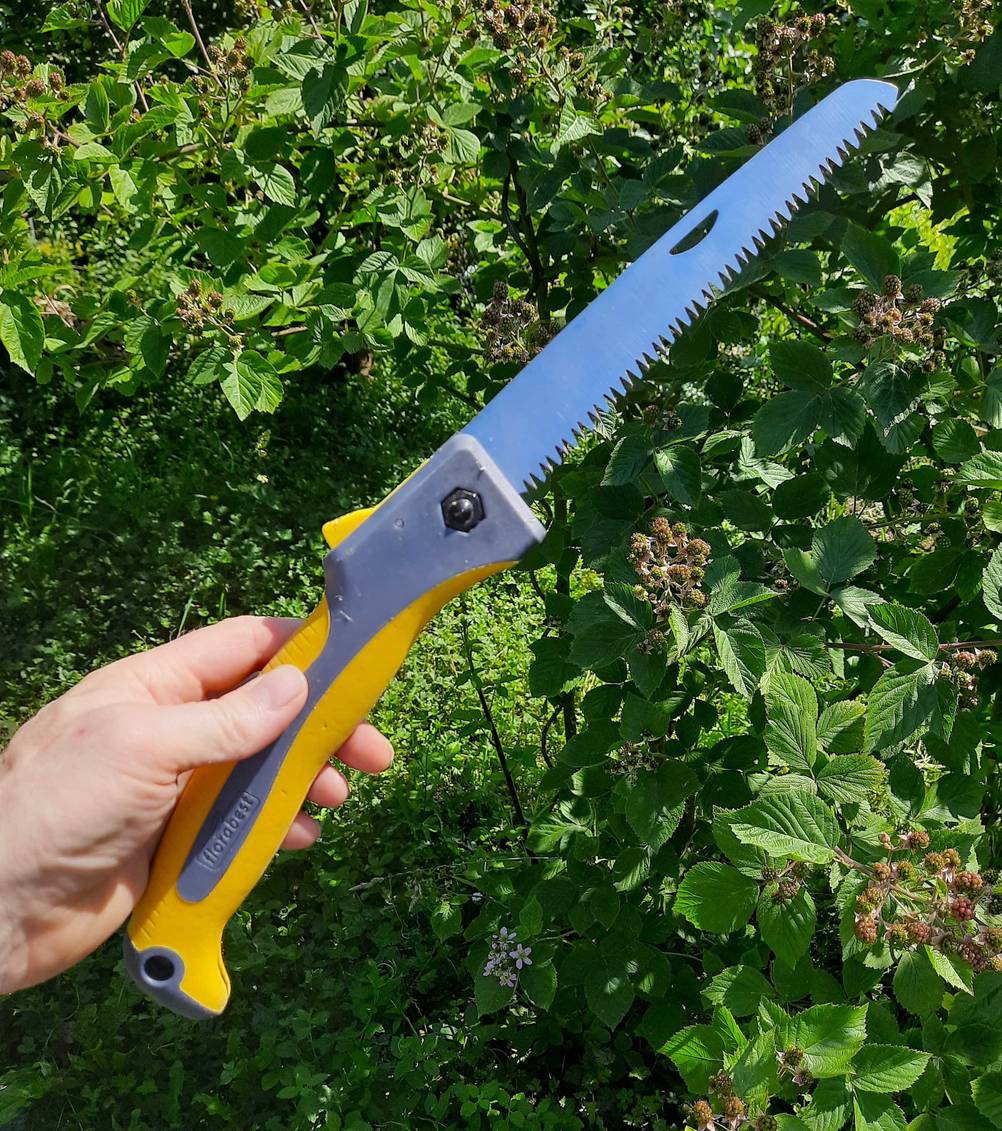 Eine getestete Holzsäge wird in der Hand gehalten.