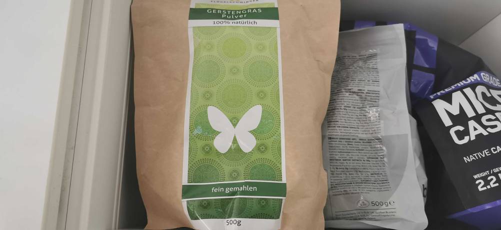 Im Test: Eine Packung Gerstengras-Pulver steht neben anderen Produkten in einem Regal.