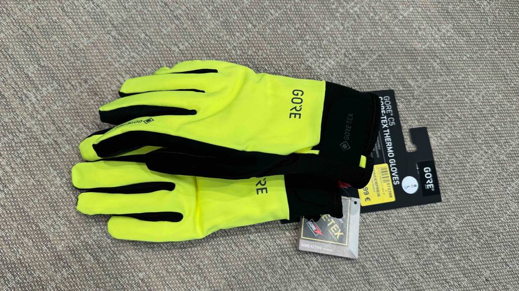 Getestet: ein Paar gelbe Fahrradhandschuhe-Winter von Gore Tex liegen aufeinander.