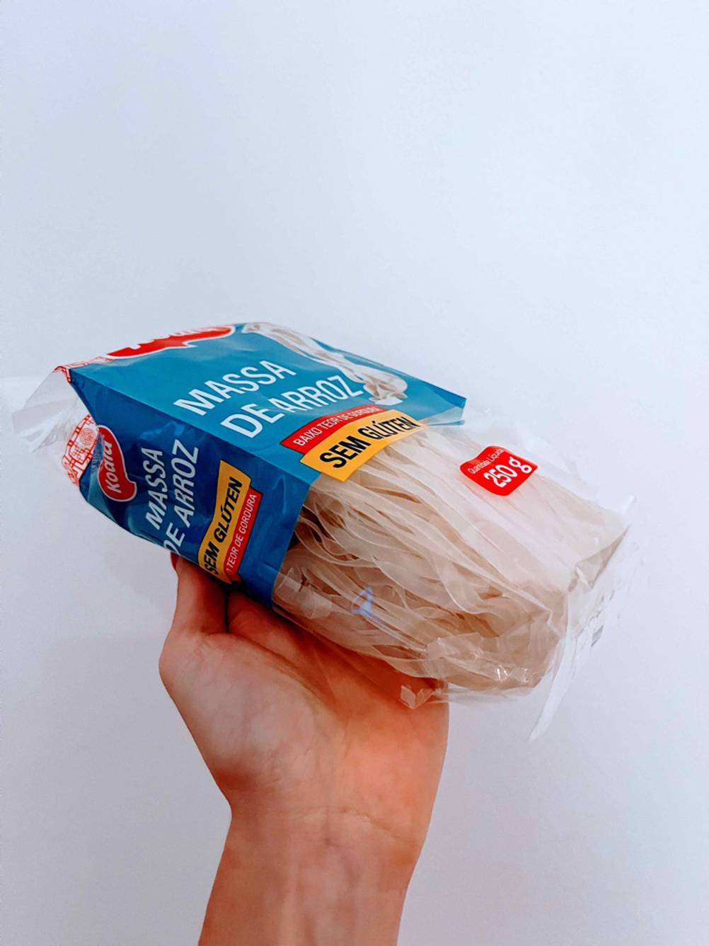 Konjak-Nudeln im Test: Eine Hand hält eine Packung vor eine helle Wand