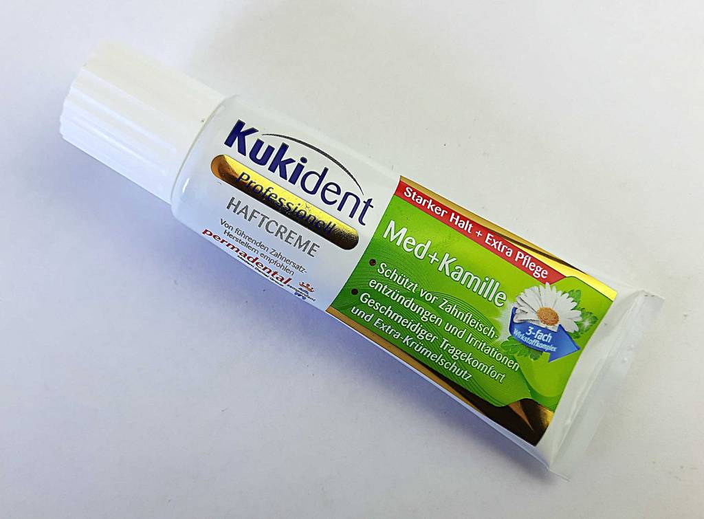 Die Haftcreme im Test liegt in der Tube von Kukident auf einer weißen Oberfläche.
