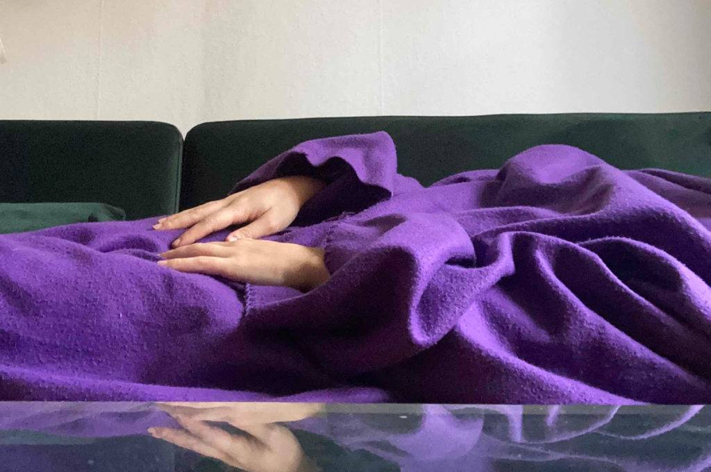 Decke-mit-Ärmeln im Test: violettfarbene angezogene Decke mit Ärmeln.
