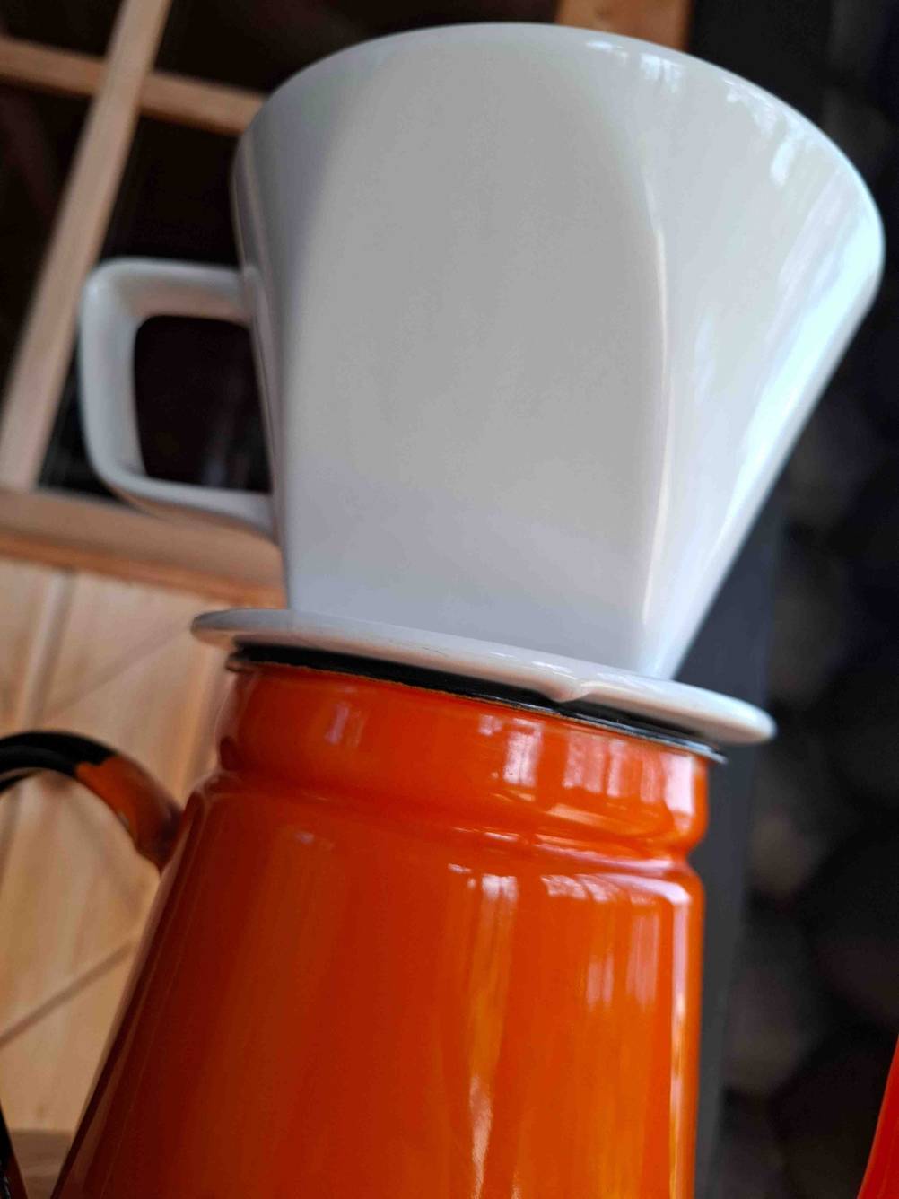 Nahaufnahme des weißen Porzellan-Kaffeefilters, der auf einer Tasse steht und getestet wird.