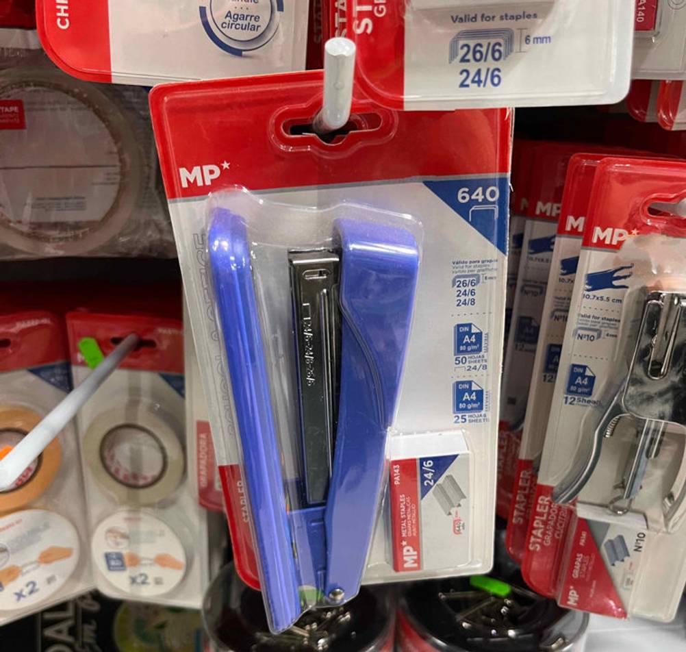 Tacker-Test: blauer Tacker hängt in einem Regal neben anderen Büroartikeln.