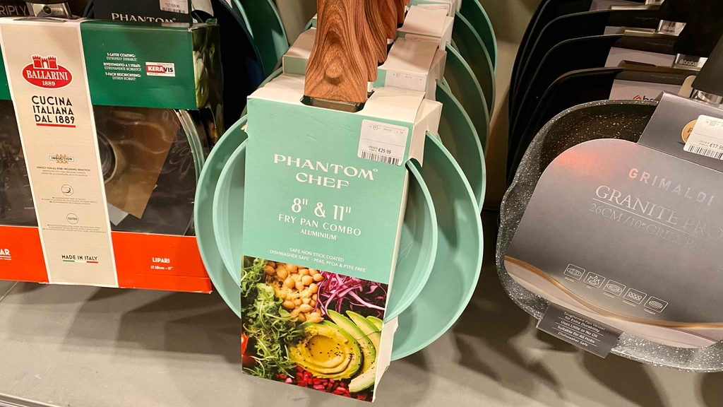 Pfannenset im Test: Mehrere Pfannensets hängen in einem Regal.