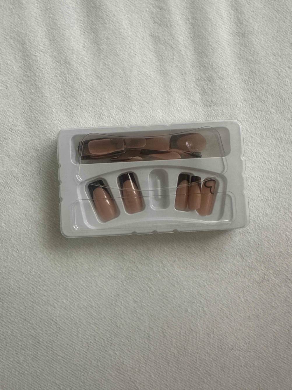 künstliche Fingernägel getestet: die Verpackung mit den Nägel darin liegen auf einem hellen Stoff.