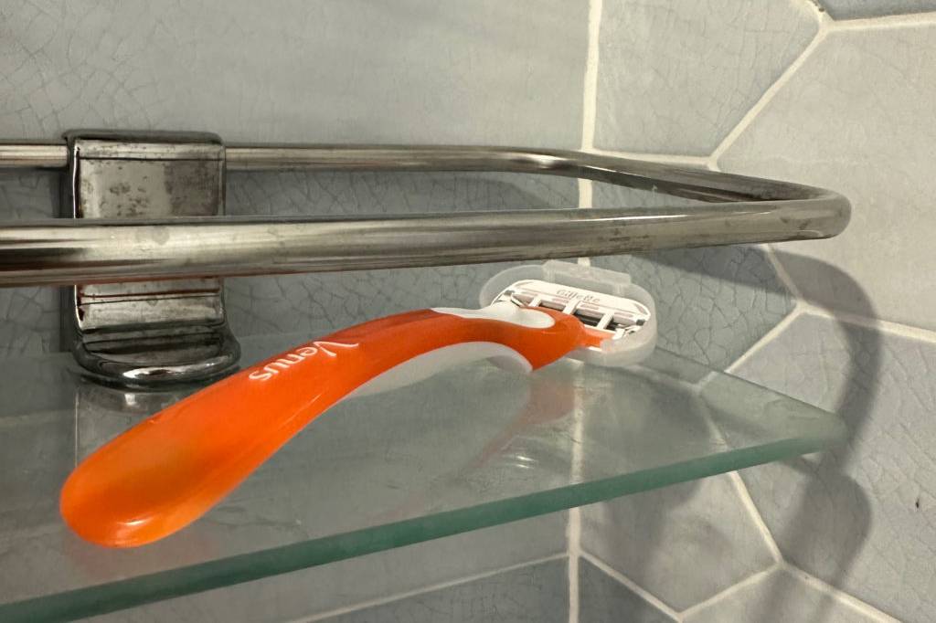 Damenrasierer auf einem Duschseifenhalter aus Glas