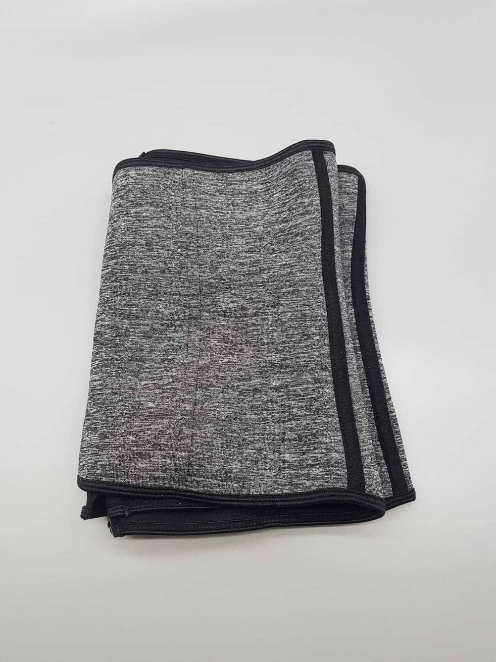 Waist-Trainer getestet: ein grauer zusammengefalteter Waist-Trainer auf einer weißen Fläche liegend.