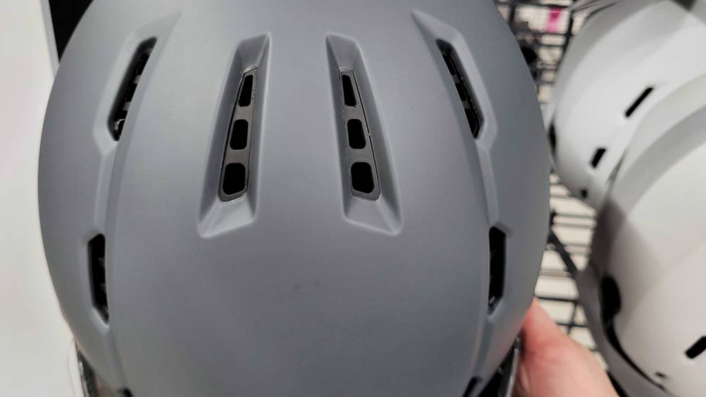 Skilhelm-mit-Visier im Test: Belüftungslöcher eines grauen Skilhelms im Fokus.